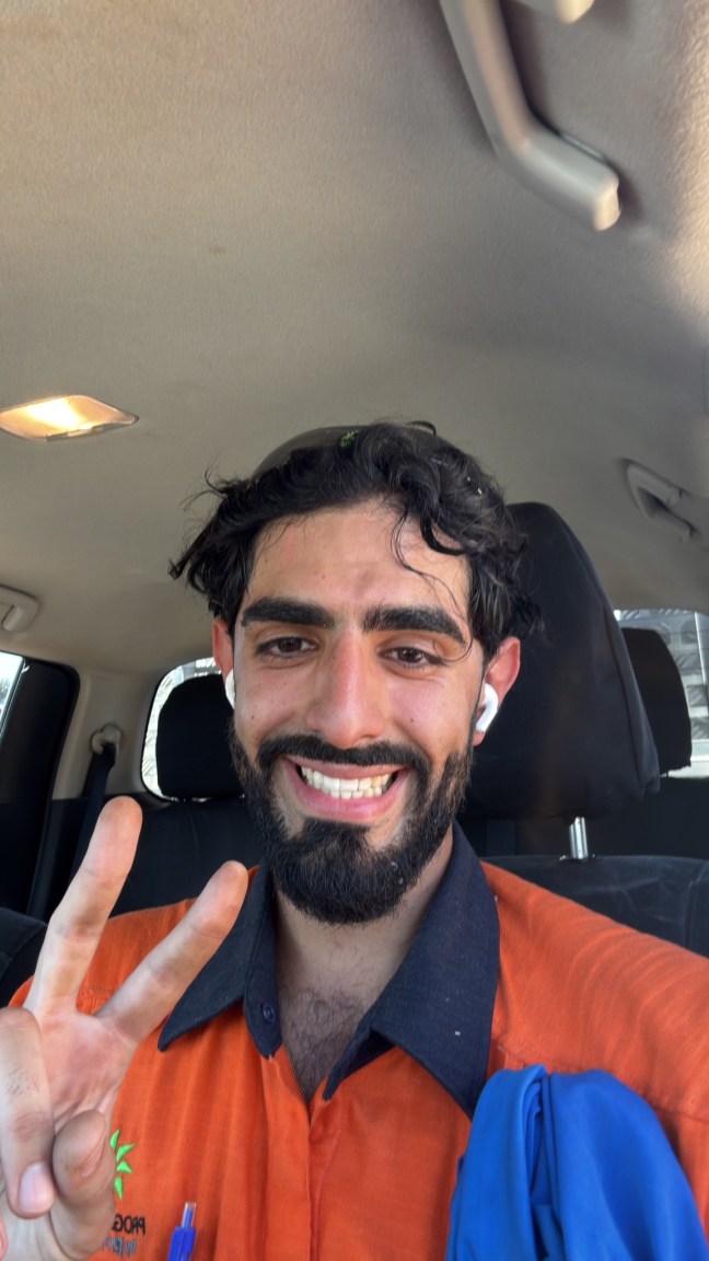 Selfie sorridente e sudato in automobile dopo un turno di lavoro in Australia, con uniforme arancione hi-vis